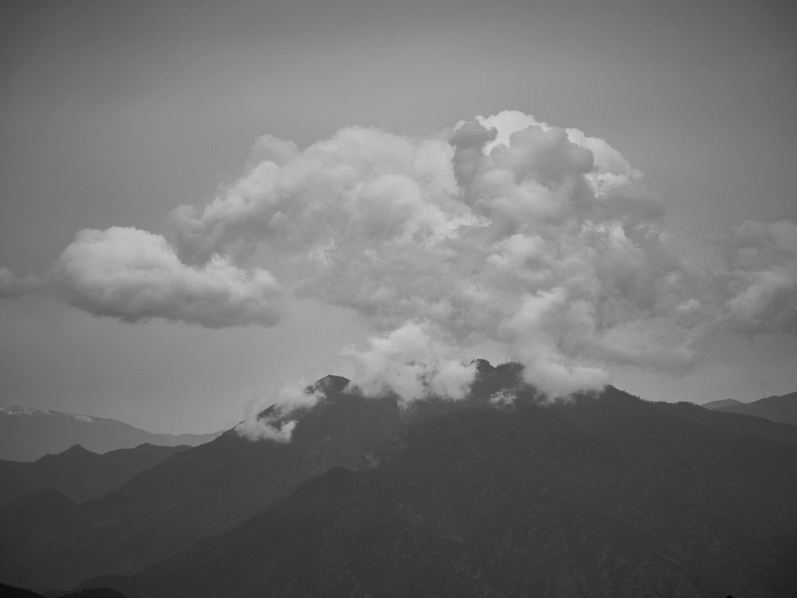 Cloud and mist conceal the outlines of mountains