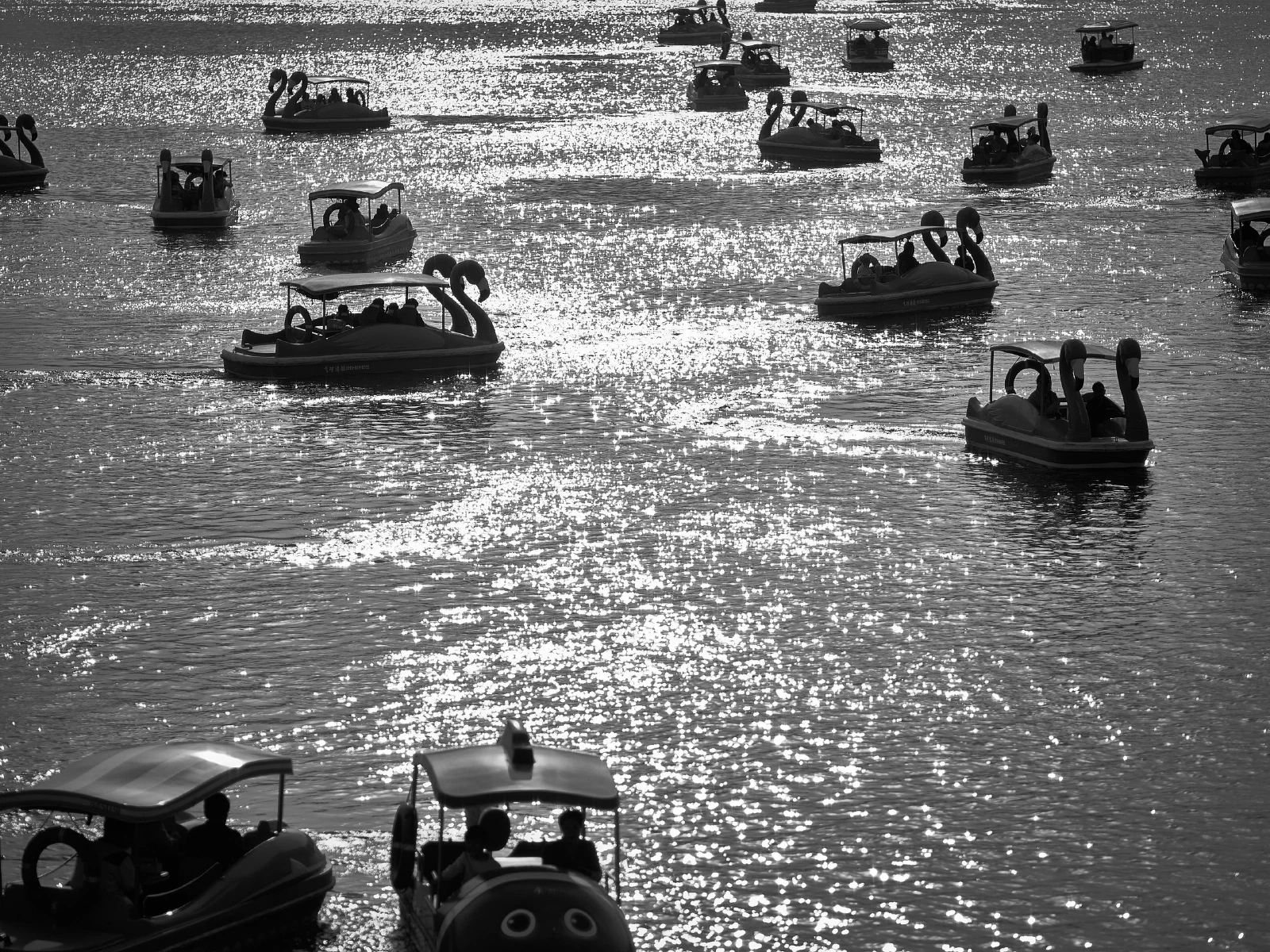 Pedal boats carrying visitors gather on the water.