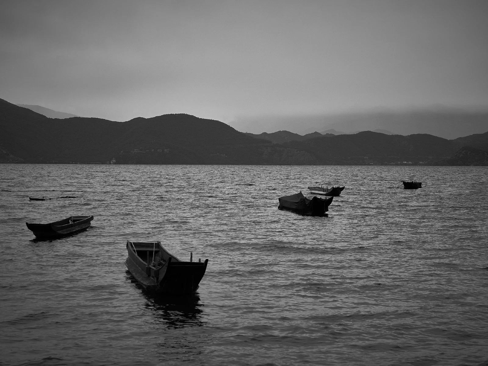 Water, a distant shore and boats at rest
