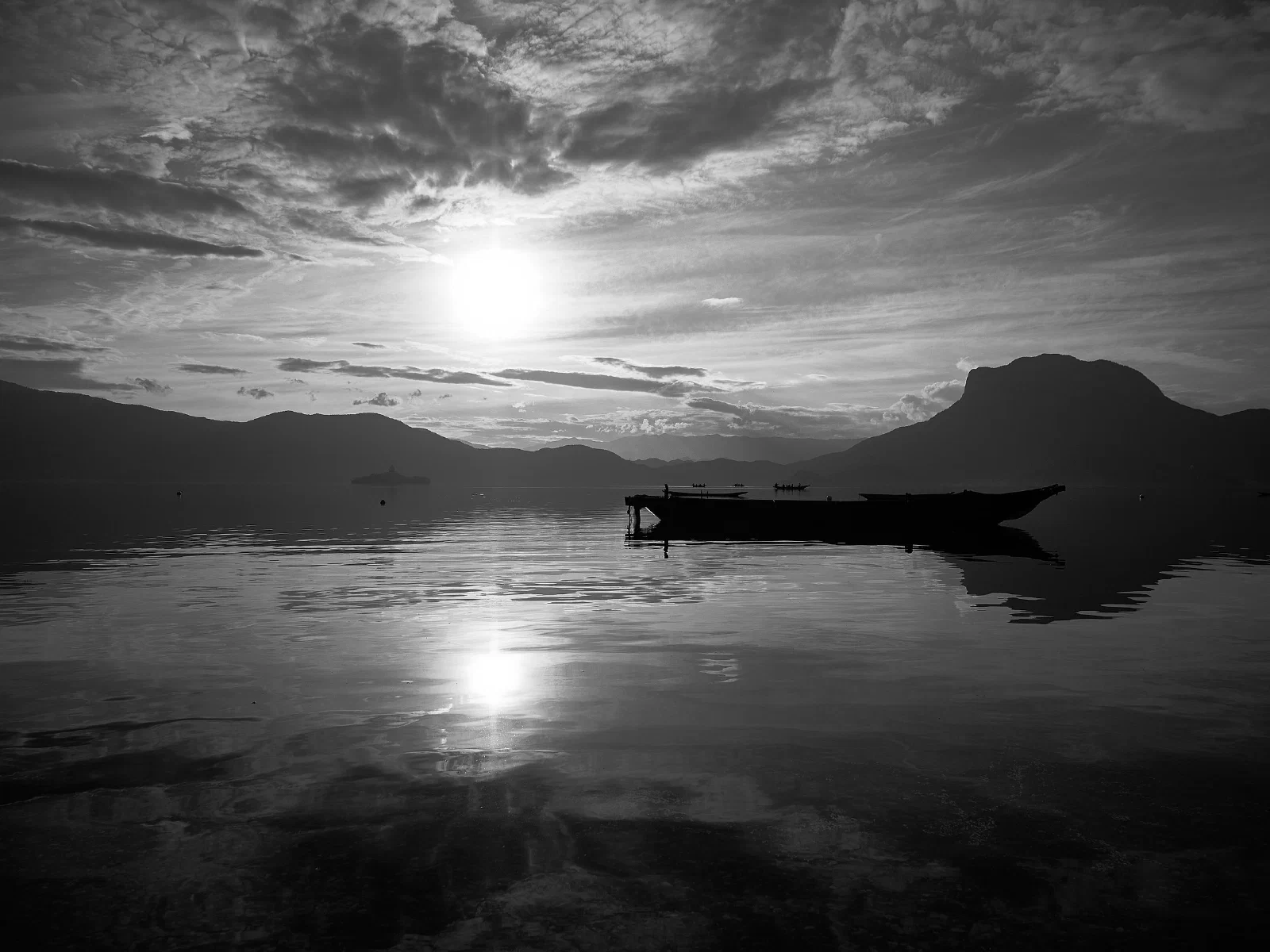 Water, a distant shore and boats at rest