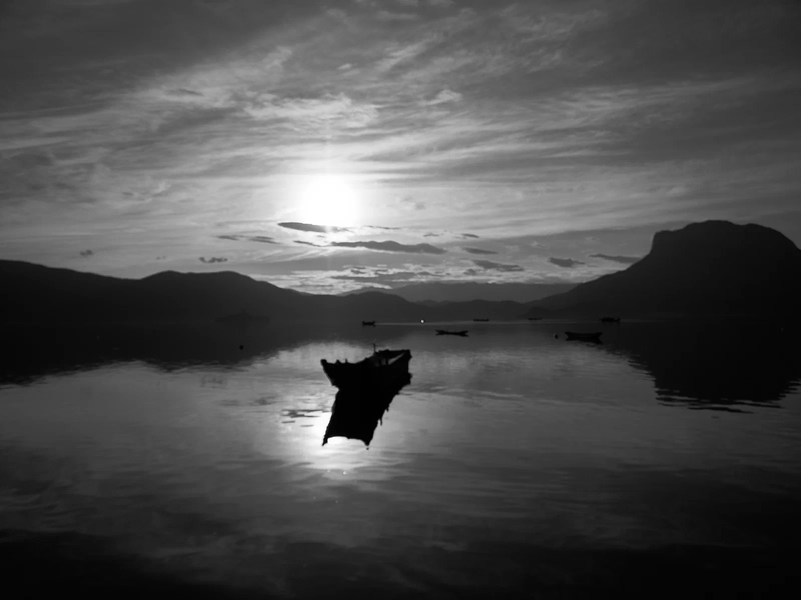 Water, a distant shore and boats at rest