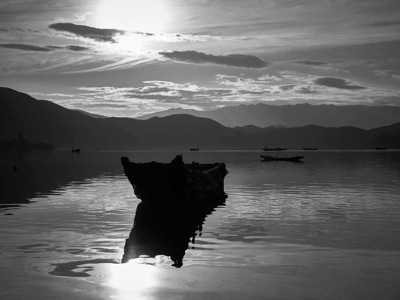 Water, a distant shore and boats at rest