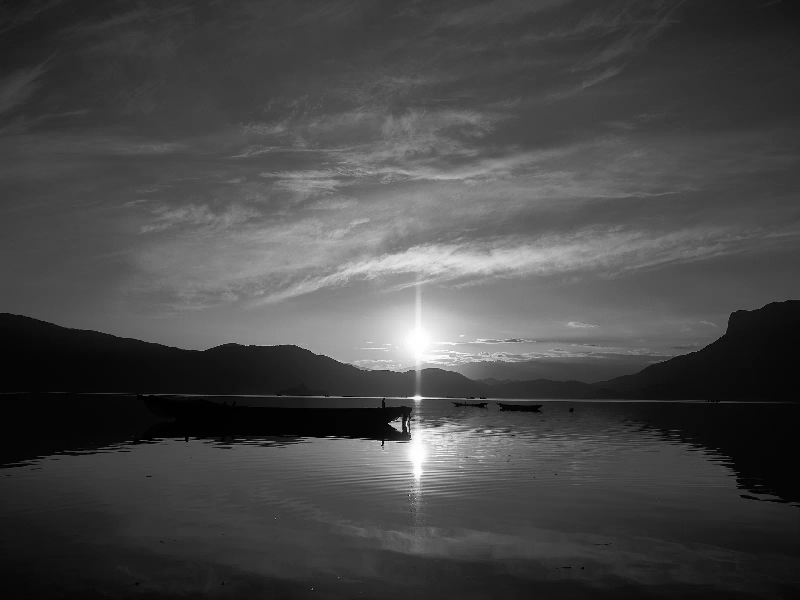 Water, a distant shore and boats at rest